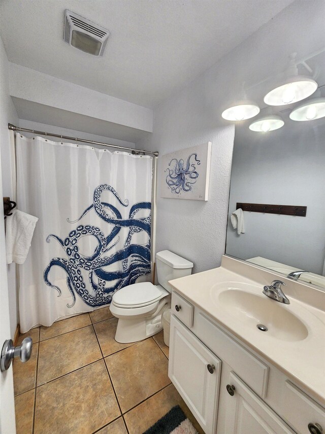 bathroom with toilet, tile patterned flooring, visible vents, and vanity