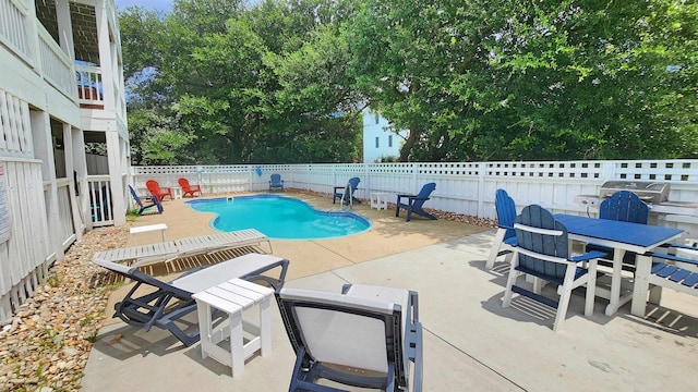 view of swimming pool featuring grilling area, a patio area, fence, and a fenced in pool