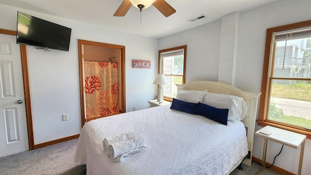 carpeted bedroom with visible vents, ceiling fan, and baseboards