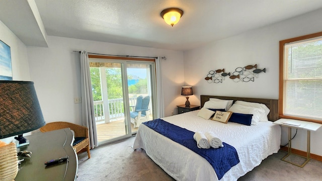 carpeted bedroom with access to outside and baseboards