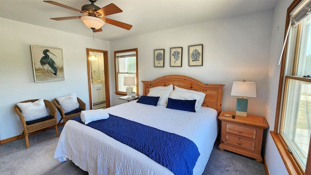 bedroom featuring a ceiling fan, baseboards, dark carpet, and connected bathroom