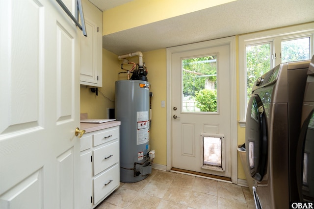 1115 Waterlily Rd, Coinjock, NC 27923 - laundry area featuring cabinet space, water heater, washing machine and dryer, and light tile patterned floors