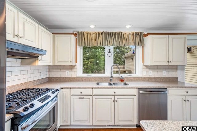 1115 Waterlily Rd, Coinjock, NC 27923 - kitchen featuring appliances with stainless steel finishes, under cabinet range hood, tasteful backsplash, light countertops, and white cabinets