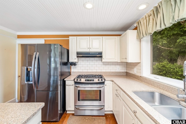 1115 Waterlily Rd, Coinjock, NC 27923 - kitchen featuring gas stove, fridge with ice dispenser, under cabinet range hood, decorative backsplash, and ornamental molding