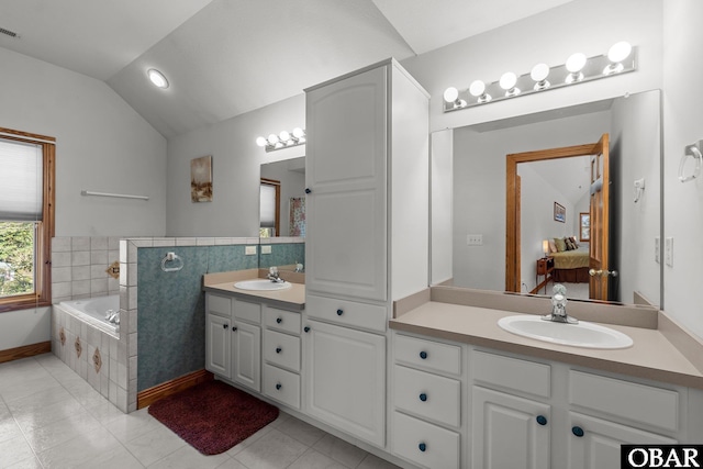 full bath featuring visible vents, vanity, vaulted ceiling, a bath, and tile patterned floors