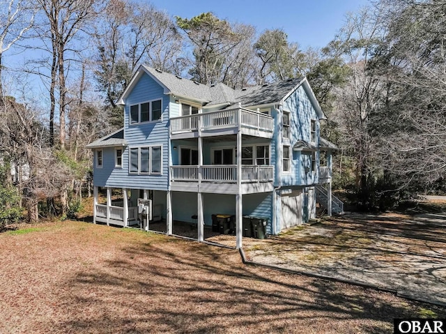 rear view of house featuring a balcony and an attached garage