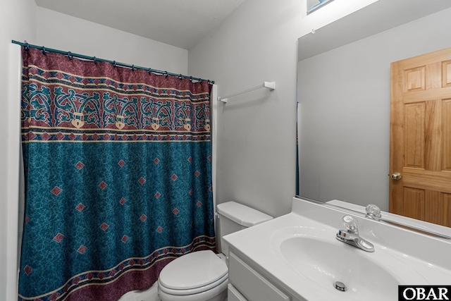 bathroom featuring curtained shower, vanity, and toilet