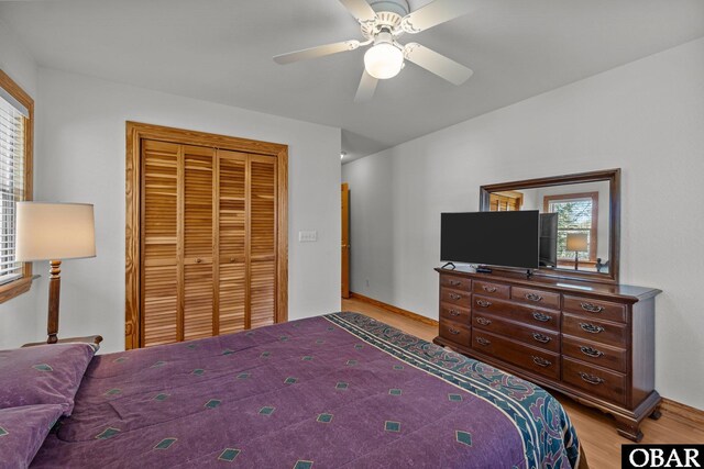 bedroom featuring a ceiling fan, a closet, and wood finished floors