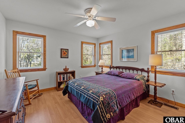 bedroom with light wood-style floors, baseboards, and a ceiling fan