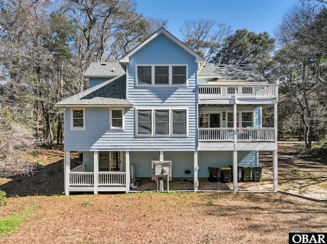 rear view of house featuring roof with shingles