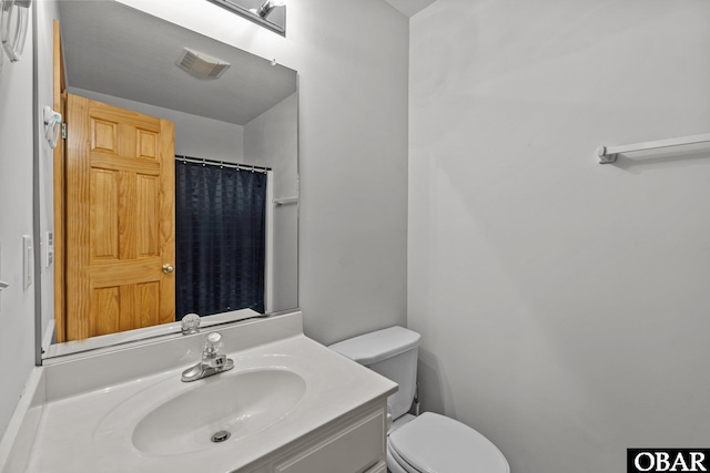 full bathroom featuring a shower with curtain, visible vents, vanity, and toilet