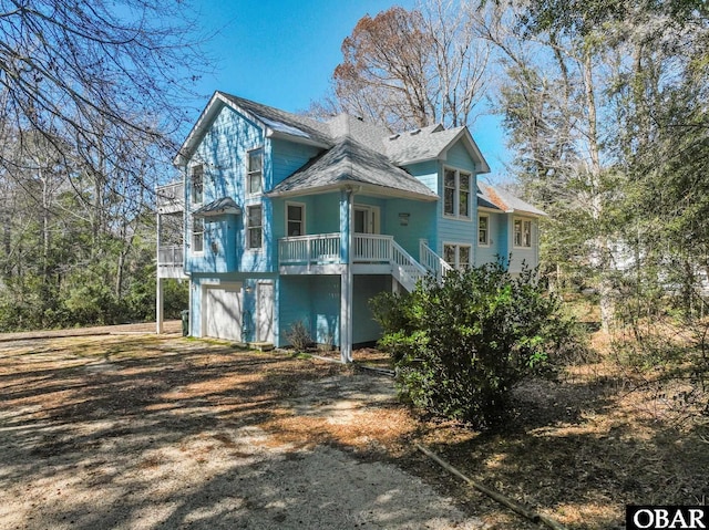 view of front of home featuring driveway, stairway, and an attached garage