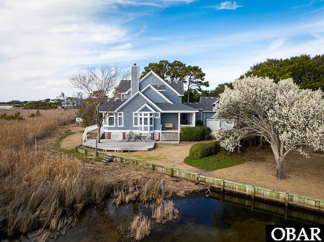 back of property with a deck with water view
