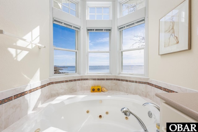 full bath with vanity, a healthy amount of sunlight, and a whirlpool tub