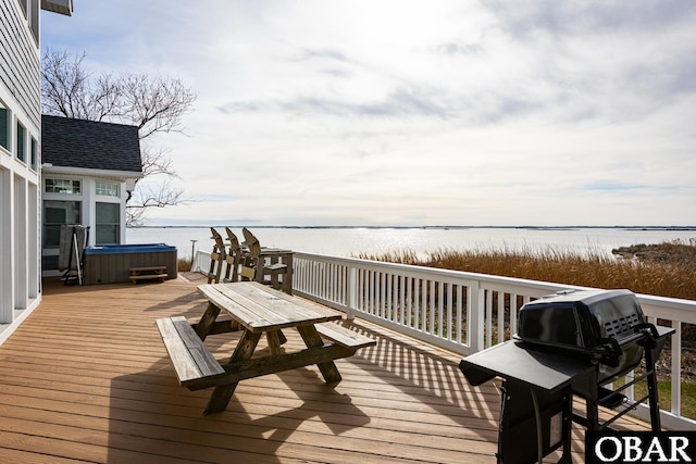 wooden terrace with grilling area, a water view, and a hot tub
