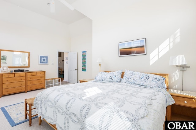 bedroom featuring light carpet and a towering ceiling