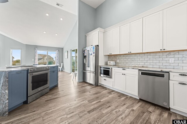 1024 Lighthouse Dr Lot 14, Corolla, NC 27927 - kitchen with stainless steel appliances, light wood-style flooring, backsplash, white cabinets, and high vaulted ceiling