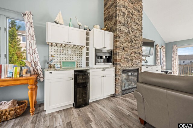 1024 Lighthouse Dr Lot 14, Corolla, NC 27927 - kitchen with beverage cooler, light wood-type flooring, open shelves, white cabinetry, and high vaulted ceiling