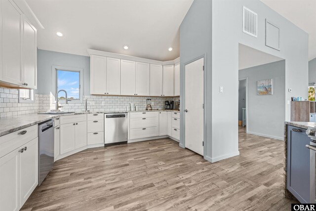 1024 Lighthouse Dr Lot 14, Corolla, NC 27927 - kitchen with stainless steel dishwasher, backsplash, light stone countertops, white cabinetry, and recessed lighting