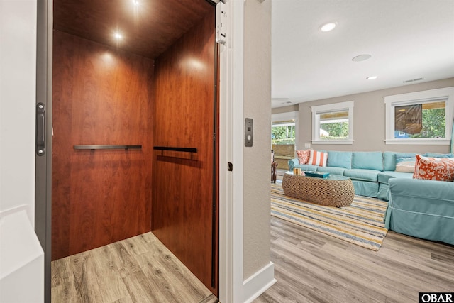 room details with recessed lighting, wood finished floors, visible vents, and elevator