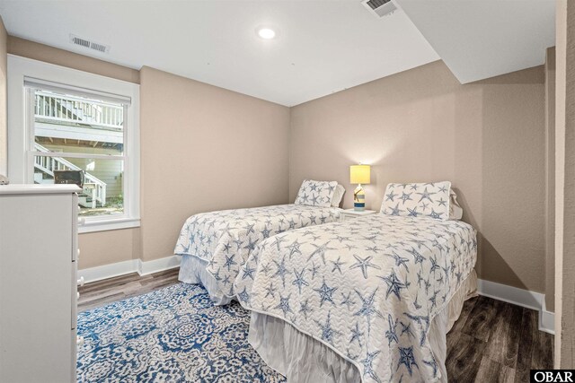 bedroom featuring visible vents, dark wood finished floors, and baseboards