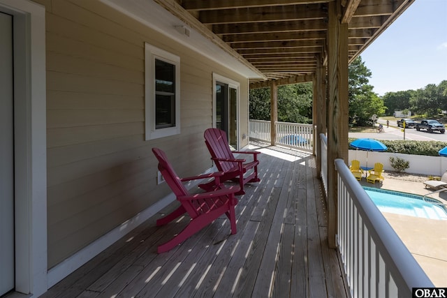 wooden terrace featuring a fenced in pool and fence