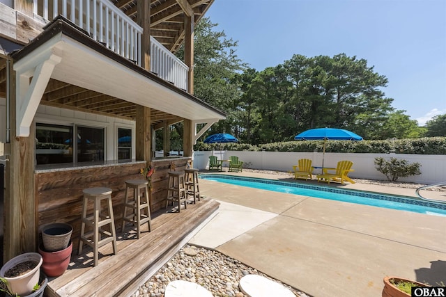 view of swimming pool featuring a fenced in pool, a patio area, a fenced backyard, and outdoor dry bar