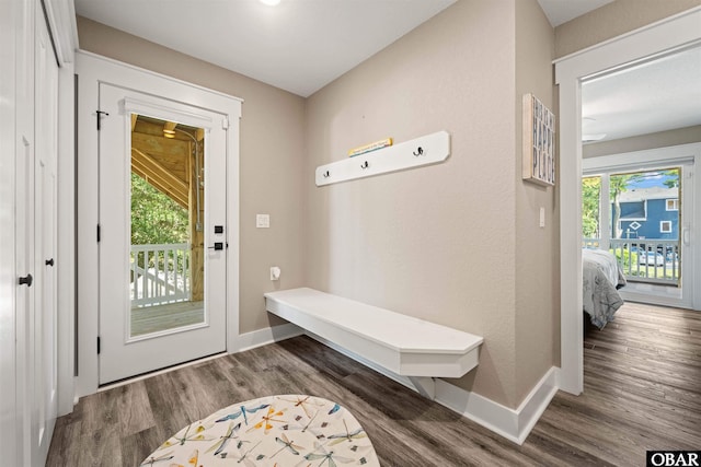 mudroom featuring dark wood-type flooring and baseboards