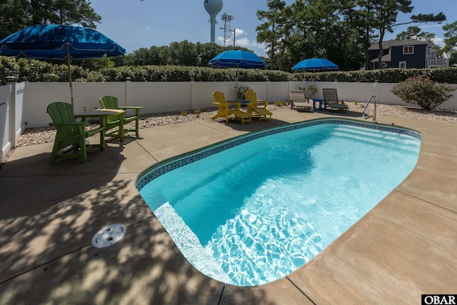 view of swimming pool featuring a patio, outdoor dining area, a fenced backyard, and a fenced in pool