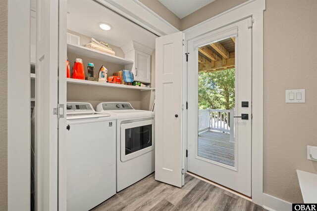 washroom with laundry area, washer and clothes dryer, and light wood-style floors