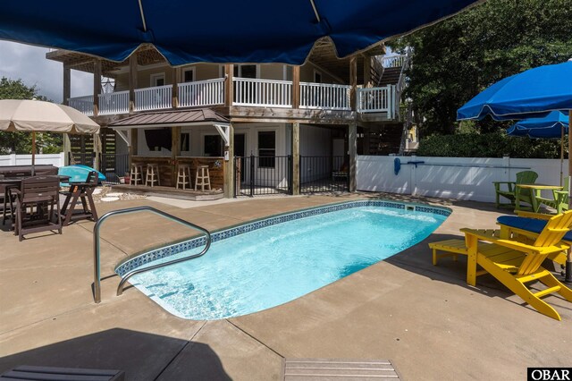 view of pool featuring a patio area, a fenced in pool, fence, and an outdoor bar