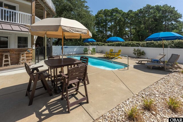 view of pool featuring fence, outdoor dry bar, a fenced in pool, and a patio