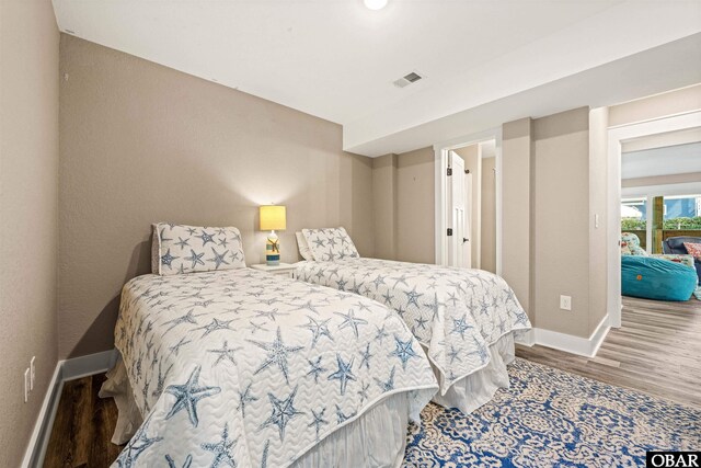 bedroom featuring visible vents, baseboards, and wood finished floors