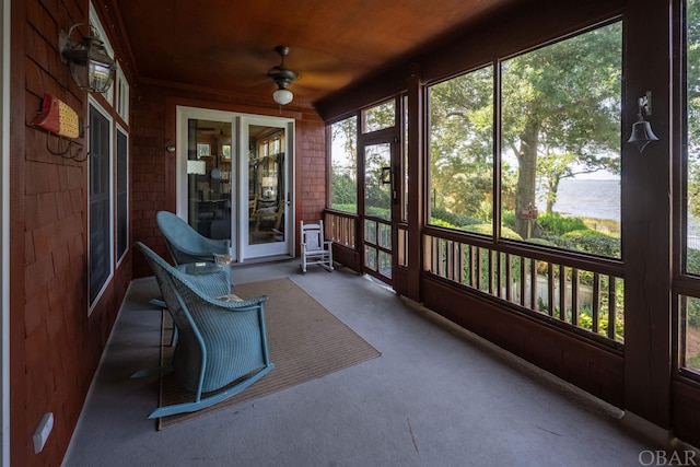 unfurnished sunroom featuring wooden ceiling, a water view, and ceiling fan