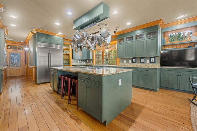 kitchen with glass insert cabinets, a kitchen island, appliances with stainless steel finishes, and green cabinets