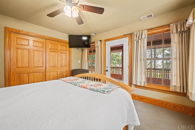 carpeted bedroom with access to outside, visible vents, ceiling fan, and a closet