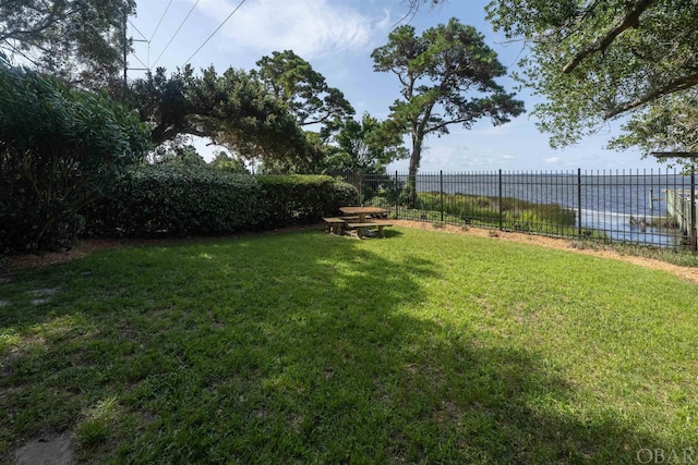 view of yard with a water view and fence