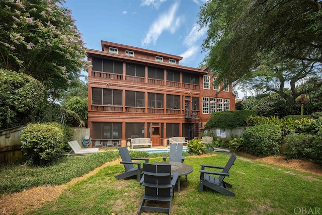 back of property featuring stairs, a lawn, and a sunroom