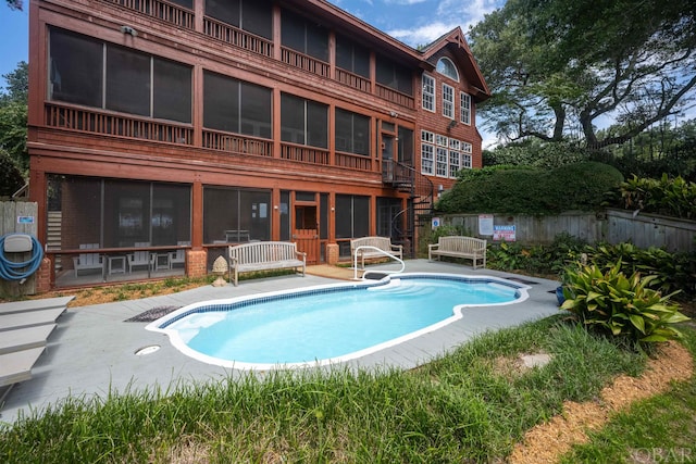 view of pool with a sunroom, a patio, fence, and a fenced in pool