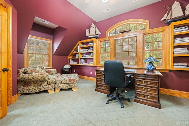 carpeted home office with lofted ceiling, plenty of natural light, visible vents, and baseboards