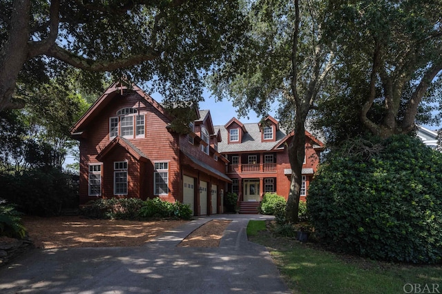 view of front facade featuring driveway and a balcony