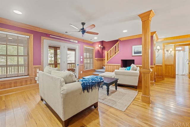 living room featuring light wood finished floors, decorative columns, and wainscoting