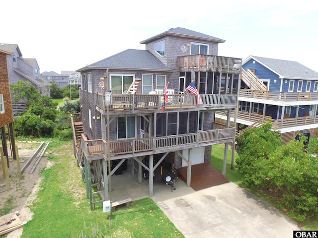 58208 Sand Rd Lot 19, Hatteras, NC 27943 - back of property featuring a garage, driveway, a wooden deck, and a shingled roof