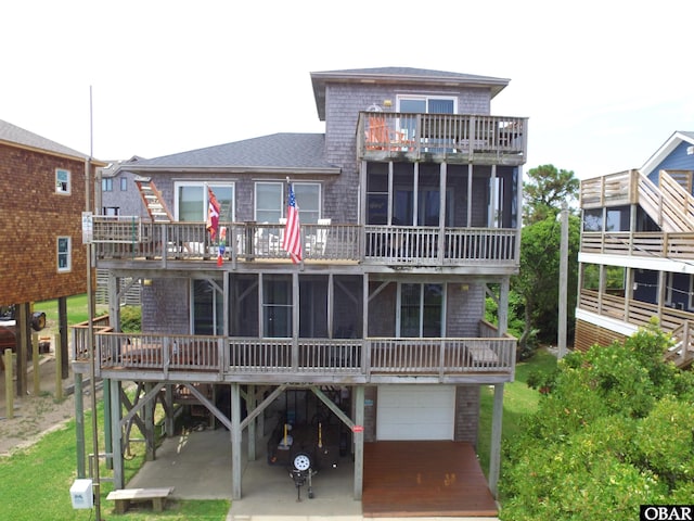 58208 Sand Rd Lot 19, Hatteras, NC 27943 - back of property featuring a garage, a balcony, a sunroom, and driveway