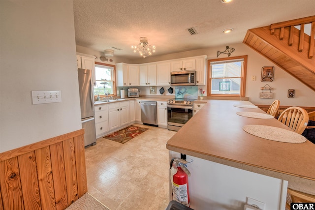 58208 Sand Rd Lot 19, Hatteras, NC 27943 - kitchen featuring stainless steel appliances, a chandelier, white cabinetry, a peninsula, and recessed lighting