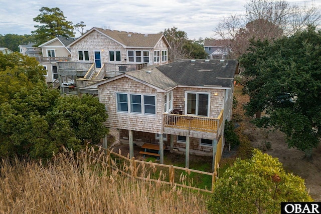 back of property with roof with shingles and a wooden deck