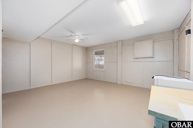 interior space with concrete flooring and a ceiling fan