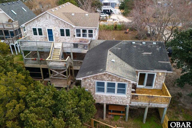 rear view of house featuring a shingled roof and a deck