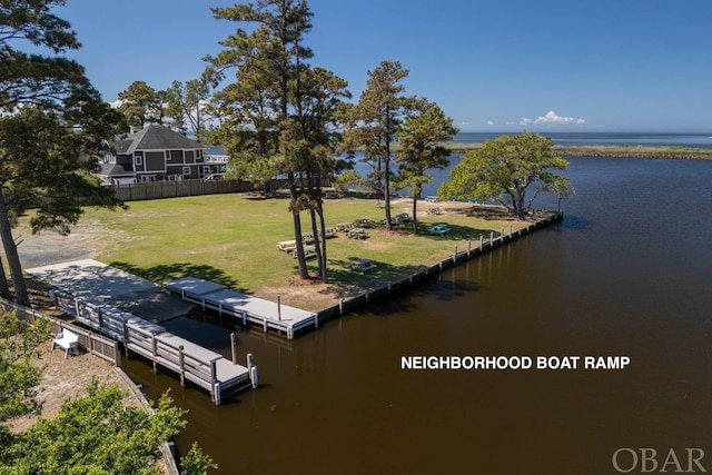 dock area featuring a water view, a yard, and fence