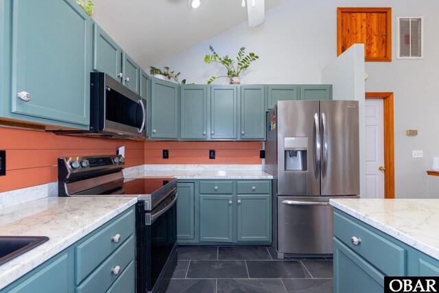 kitchen featuring appliances with stainless steel finishes, lofted ceiling, visible vents, and blue cabinetry